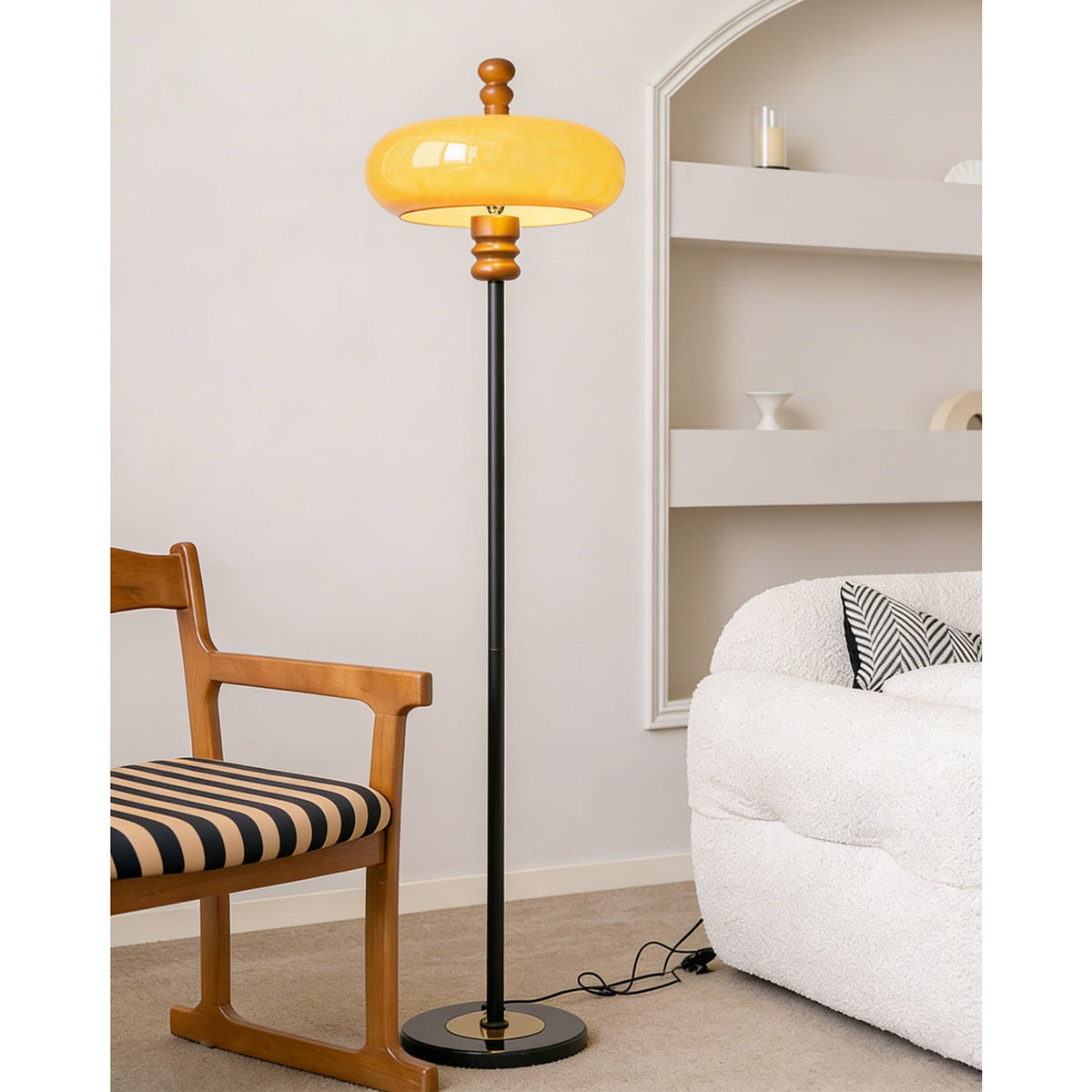 Full view of this Clérachic floor lamp beside a striped-seat wooden chair and a white boucle sofa, with its cord trailing on the floor.