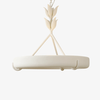 White carved plaster ring chandelier on a plain white backdrop, hung from a leaf-shaped stem and three slim rods; a Clérachic ceiling light.
