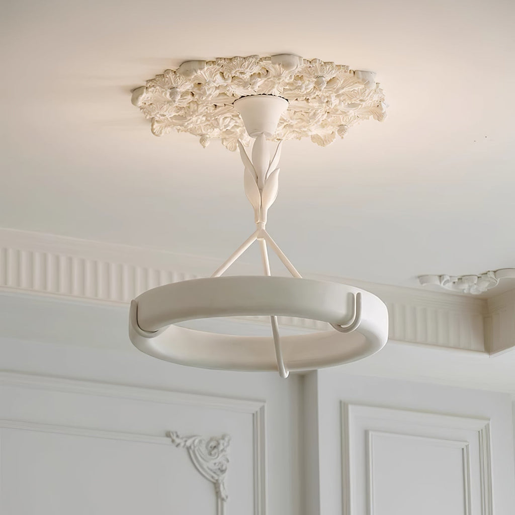 Seen from below, this Clérachic chandelier hangs from a carved plaster ceiling rose above panelled white walls and a fluted cornice.