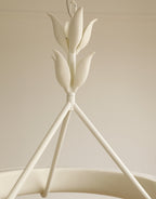 Close view of the layered plaster leaf buds where the three support rods meet, on this Clérachic chandelier.
