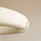 Close view of the rounded plaster rim and one curved hook on the white ring of this Clérachic chandelier.