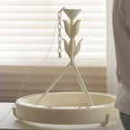 Chandelier laid out on a table in front of white blinds, showing its chain, ceiling cap, three rods and ring; a Clérachic ceiling light.