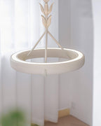 Glowing inner edge of the white plaster ring, seen against sheer curtains and a blurred plant; a Clérachic chandelier.