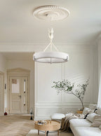 Bright hallway-style living room with a herringbone floor and a leafy plant, with this Clérachic chandelier hanging below a ribbed rose.