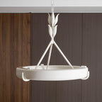 Close view of the textured white leaf buds, three rods and ring, against a ribbed walnut wall; a Clérachic chandelier.