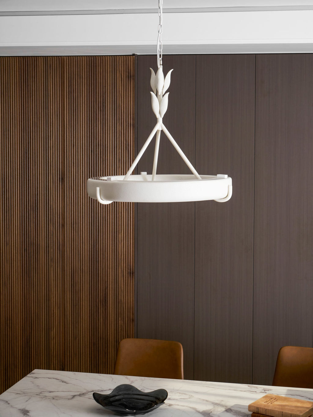 Smaller-scale view of this Clérachic chandelier hung high on a chain, with a marble table and a dark glass dish below.