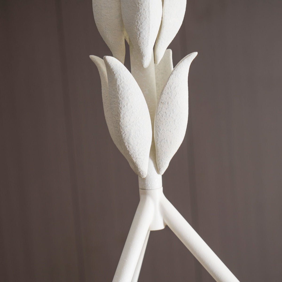 Close view of the grainy plaster leaf buds on this Clérachic chandelier, where they join the three white rods.