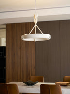 A Clérachic chandelier hangs beside a black appliance and a ribbed wooden panel, above a marble worktop with a wooden board.