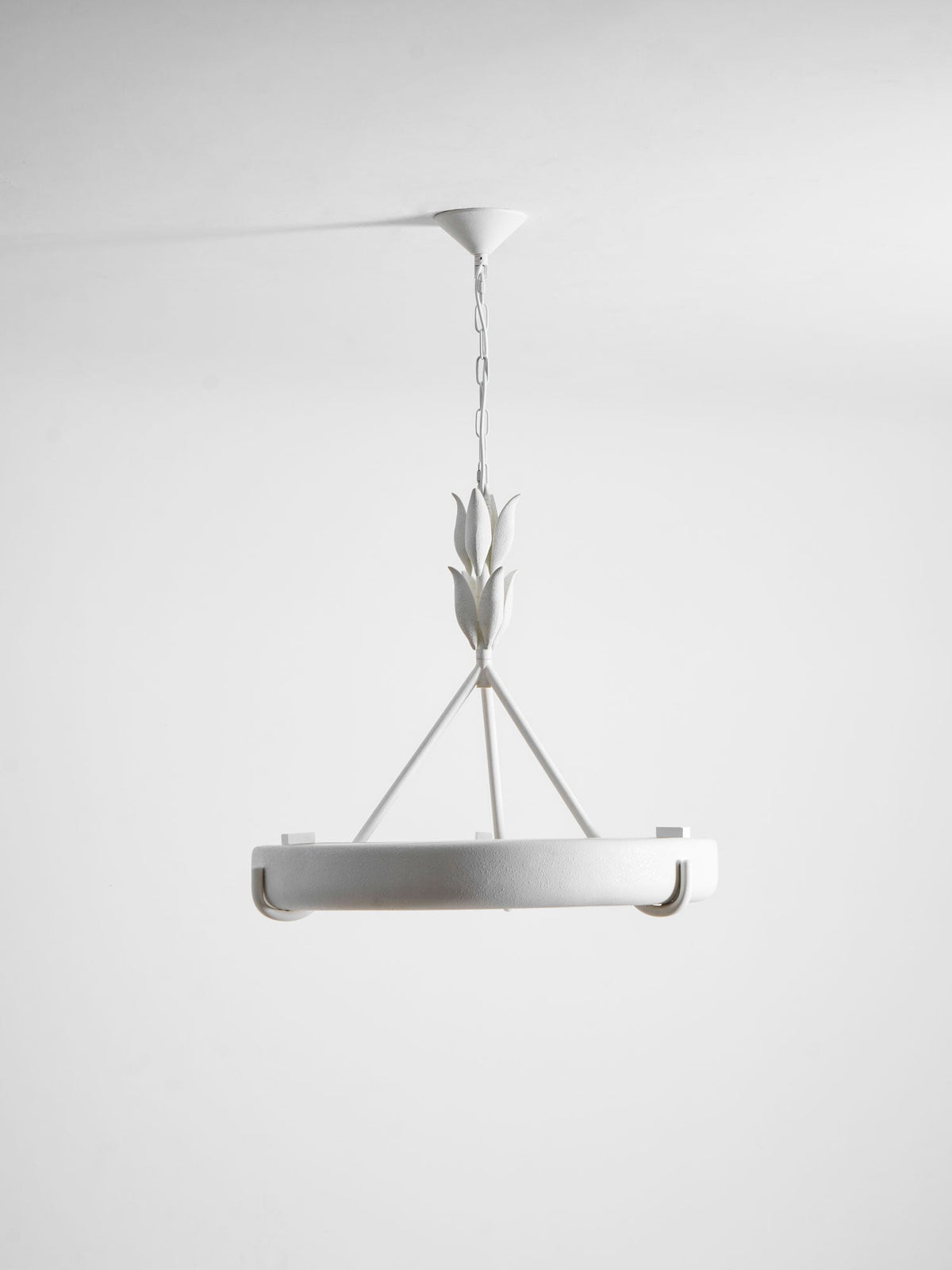 Straight-on studio shot of the white ring on its chain, with the leaf buds and three rods above; a Clérachic chandelier.