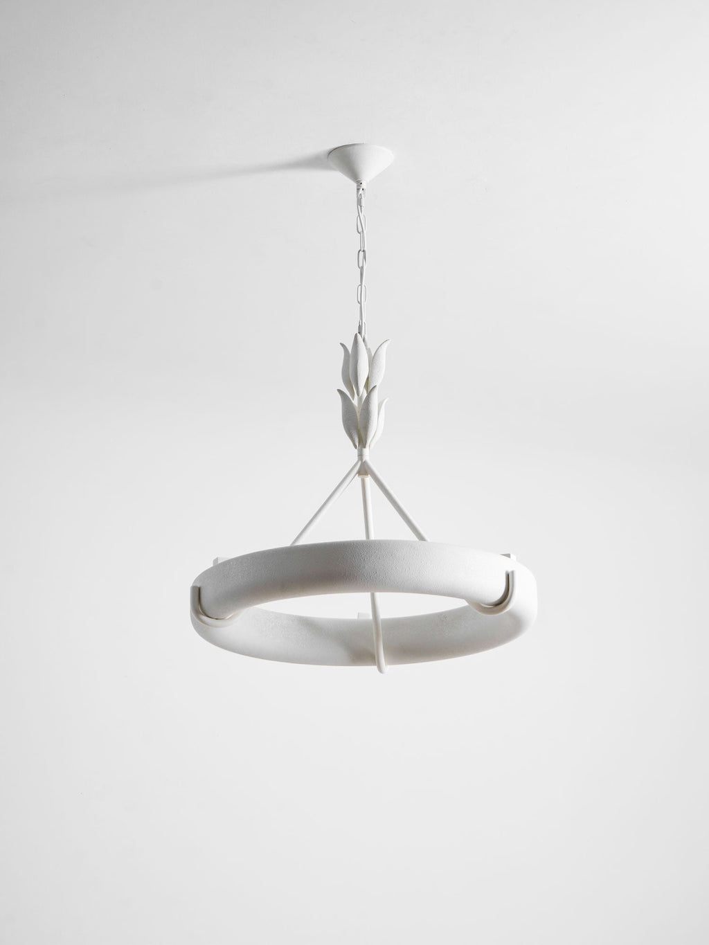 Tilted studio view of the white ring showing its curved rim and one hook, against pale grey; a Clérachic chandelier.