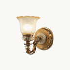 Single-head Clérachic wall light on a plain white backdrop, a frosted glass shade with a scalloped rim above a carved gold arm.