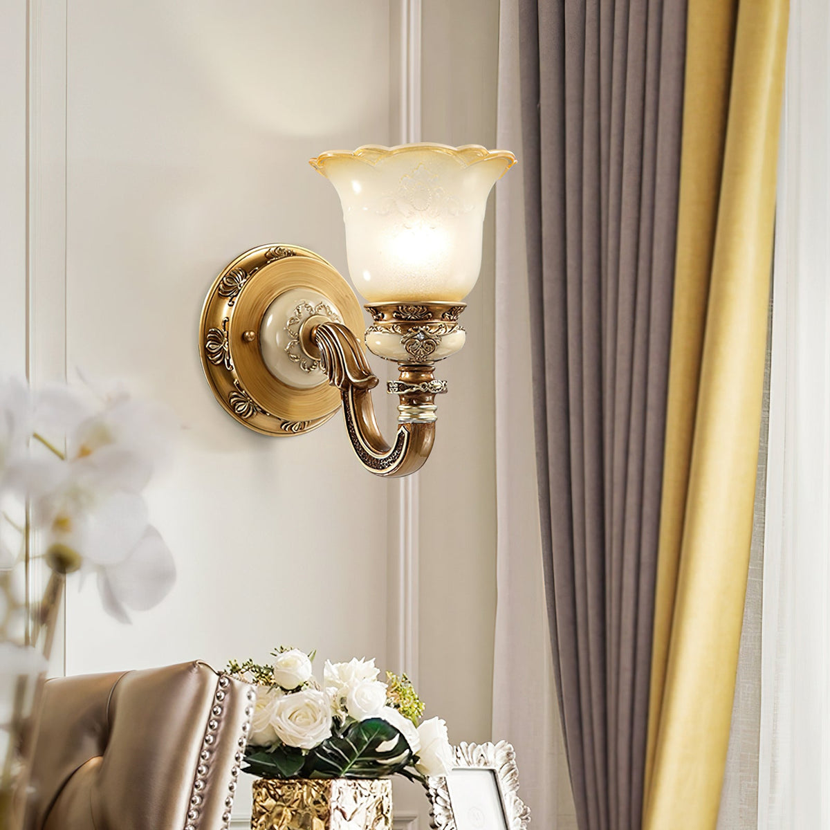 Lit single-head Clérachic wall light on a pale panelled wall, between grey-mauve curtains and a vase of white roses.