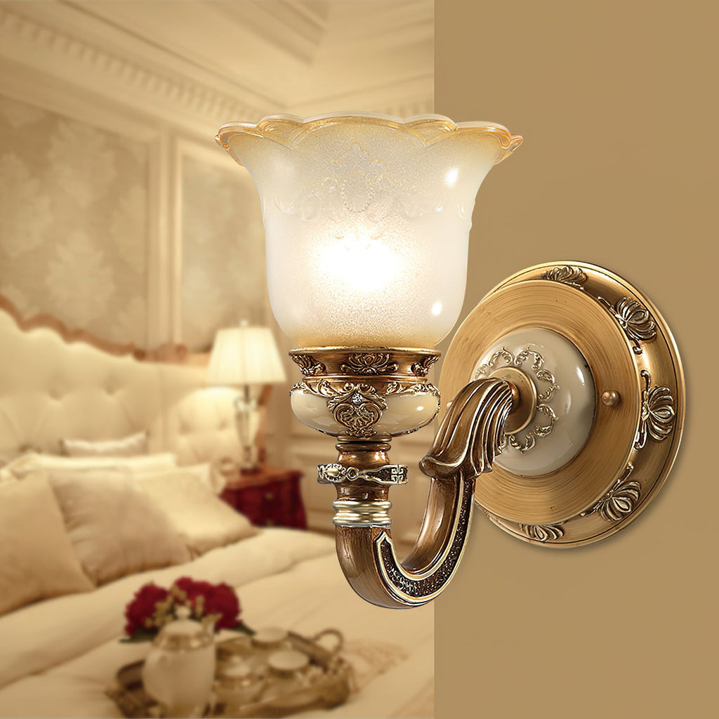 Close view of a lit single-head Clérachic wall light beside a bed with cream cushions and a tray of tea things behind.