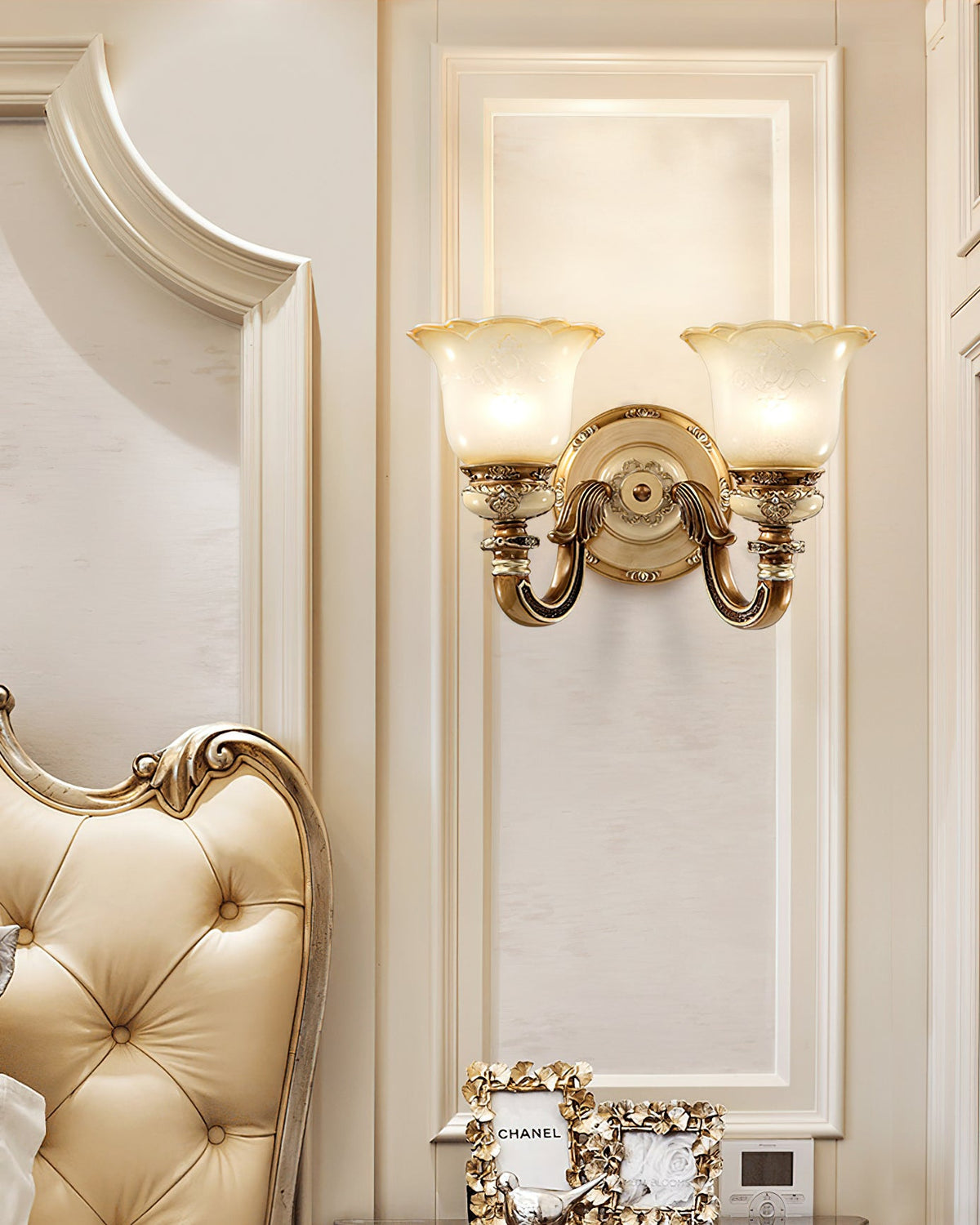 Double-head Clérachic wall light on a panelled wall above a tufted cream headboard, both frosted shades softly lit.