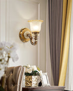 Single-head Clérachic wall light on a white wall, set between white orchid blooms and a gold-tinted vase of roses.