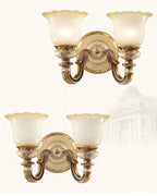 Two double-head Clérachic wall lights shown at different heights on a pale backdrop with faint architectural outlines.