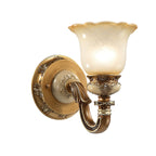 Side-on view of a single-head Clérachic wall light on white, its glass shade lit above a rounded backplate and carved arm.