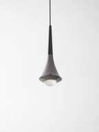 Looking up at a Clérachic pendant with a black neck, a chrome flare and a glowing opal globe under it.