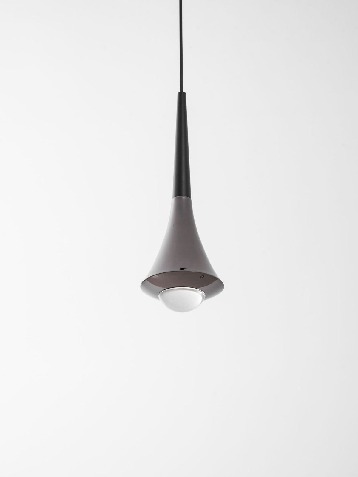 Looking up at a Clérachic pendant with a black neck, a chrome flare and a glowing opal globe under it.
