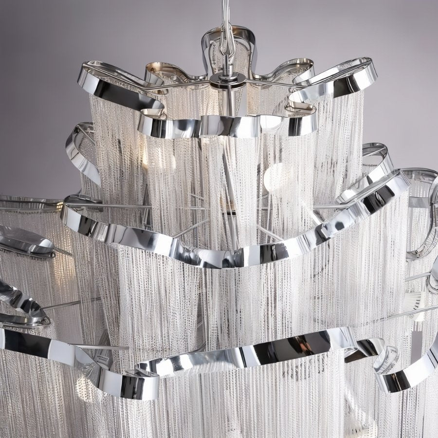 Clérachic silver chandelier close up, showing the polished curved ribbon rims and layers of fine hanging chain.