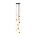 The Clérachic Cascading Globe Chandelier lit against white, honey-amber spheres falling from a matte black canopy in a tall spiral.