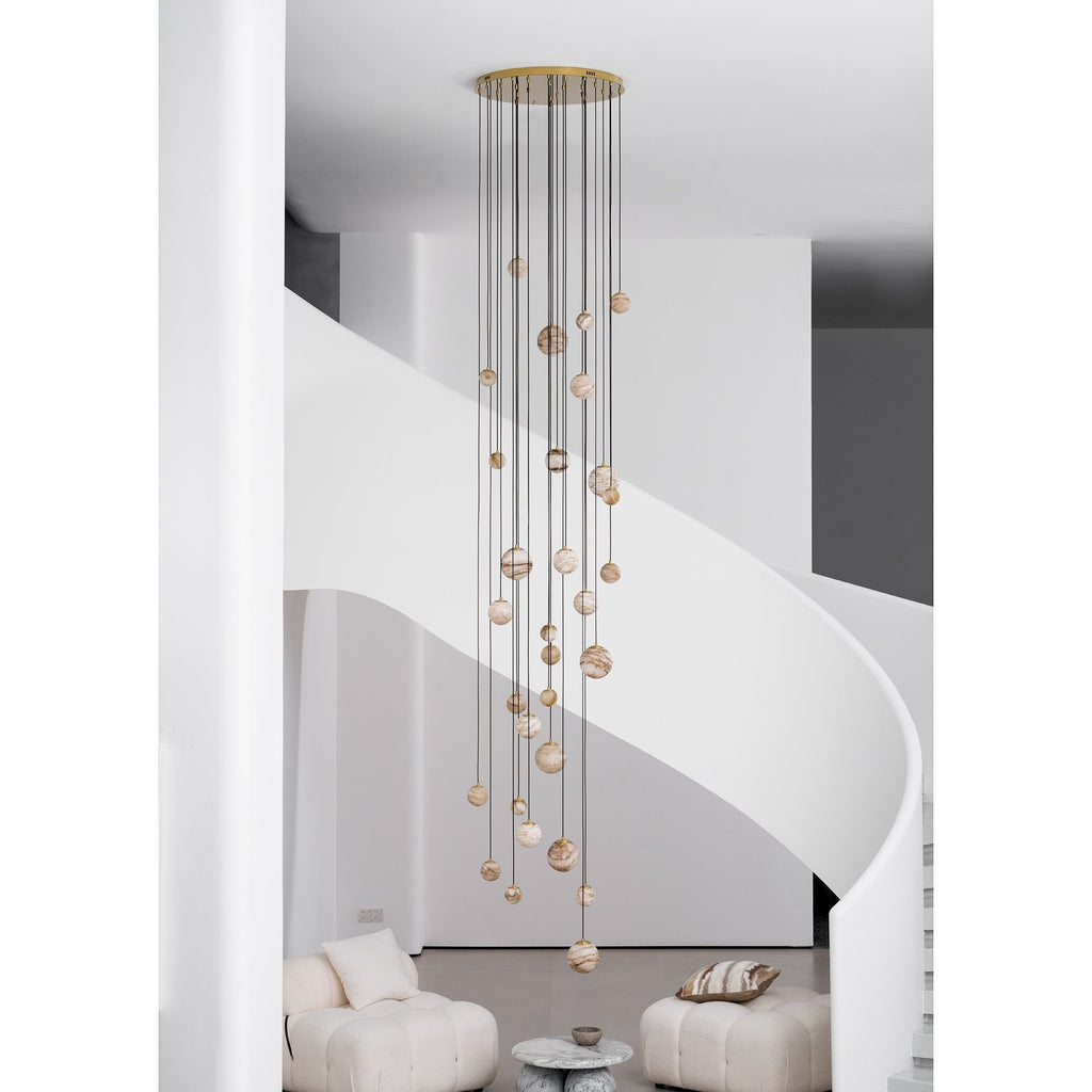 The Clérachic Cascading Globe Chandelier with a gold canopy, unlit by day, the alabaster reading warm off-white banded with tan.