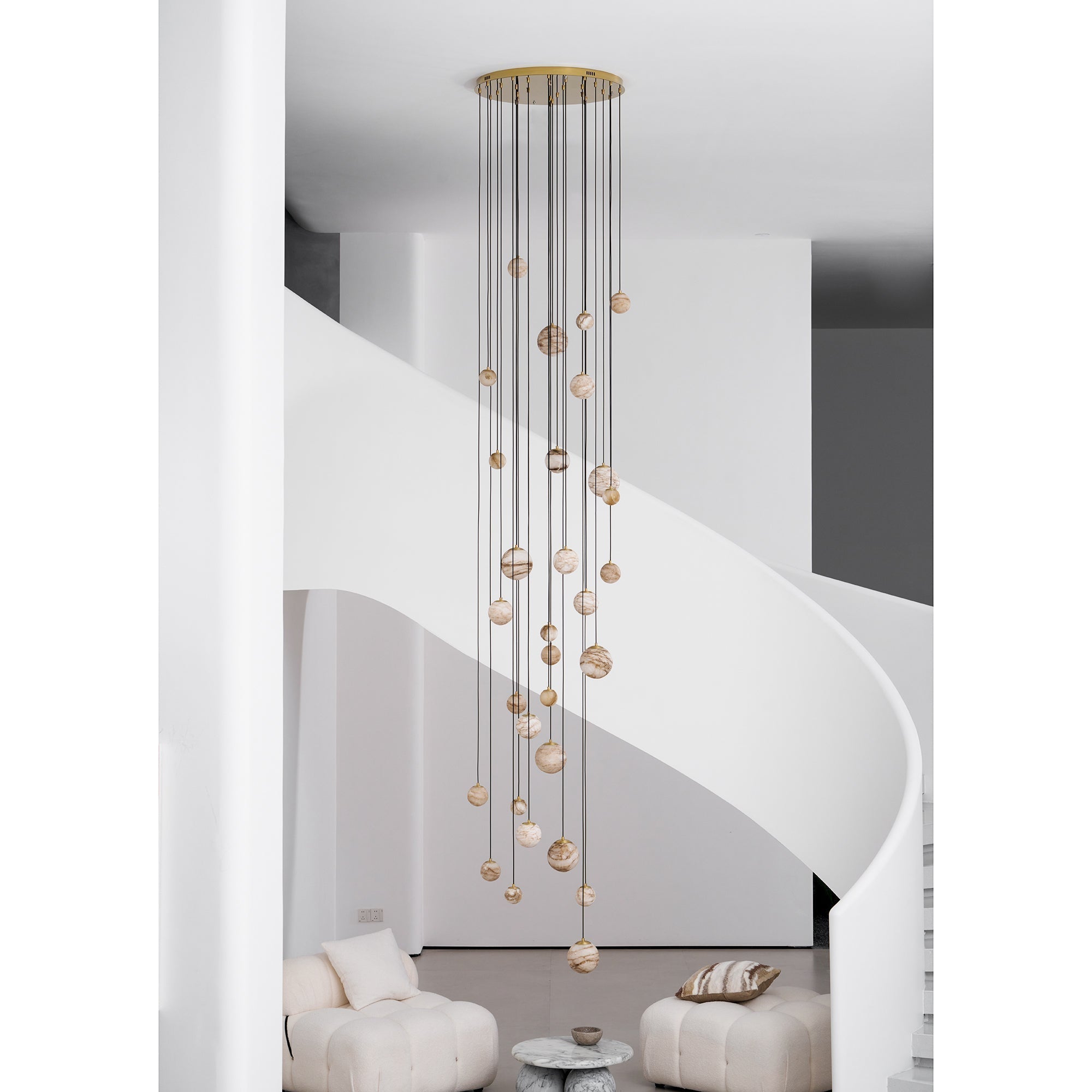 The Clérachic Cascading Globe Chandelier with a gold canopy, unlit by day, the alabaster reading warm off-white banded with tan.