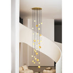 Gold-canopy version of the Clérachic Cascading Globe Chandelier lit in the stairwell, the stone deepening to honey-amber overhead.