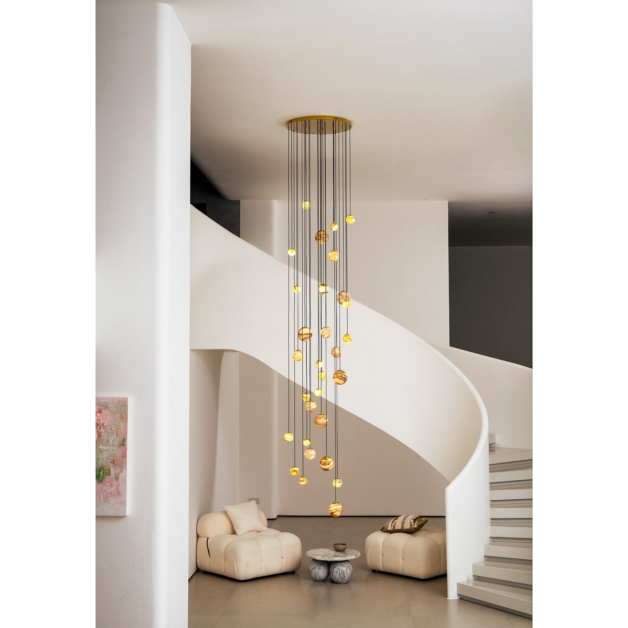 The Clérachic Cascading Globe Chandelier lit above a seating nook, its gold ceiling disc answering the brass collars on every sphere.