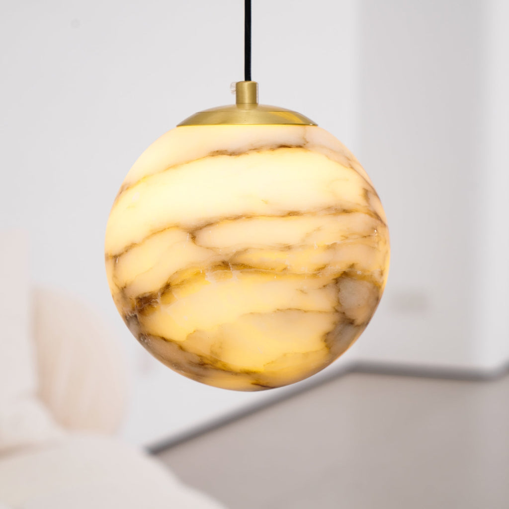 A single lit sphere from the Clérachic Cascading Globe Chandelier, quarried alabaster banding backlighting into visible strata.