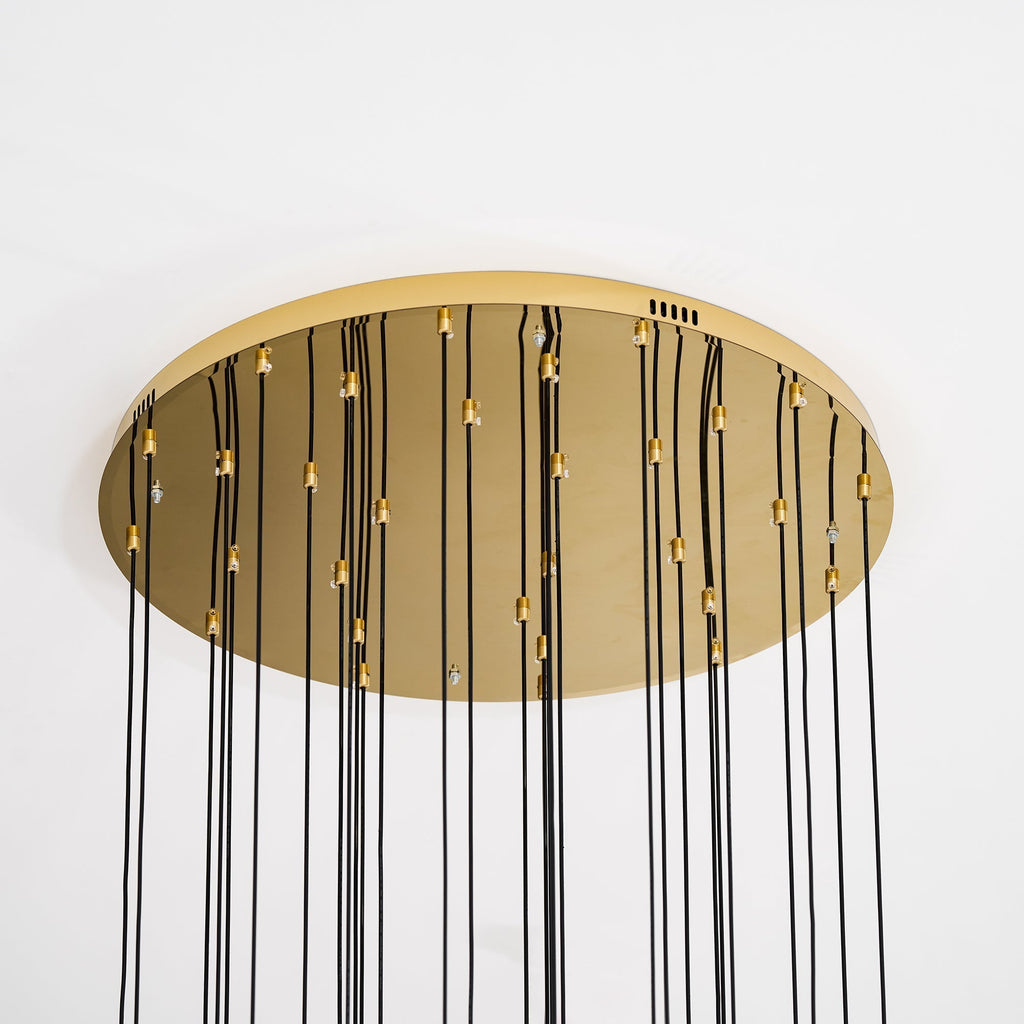 The gold canopy of the Clérachic Cascading Globe Chandelier from below, each brass cord-lock setting one flex to its own length.
