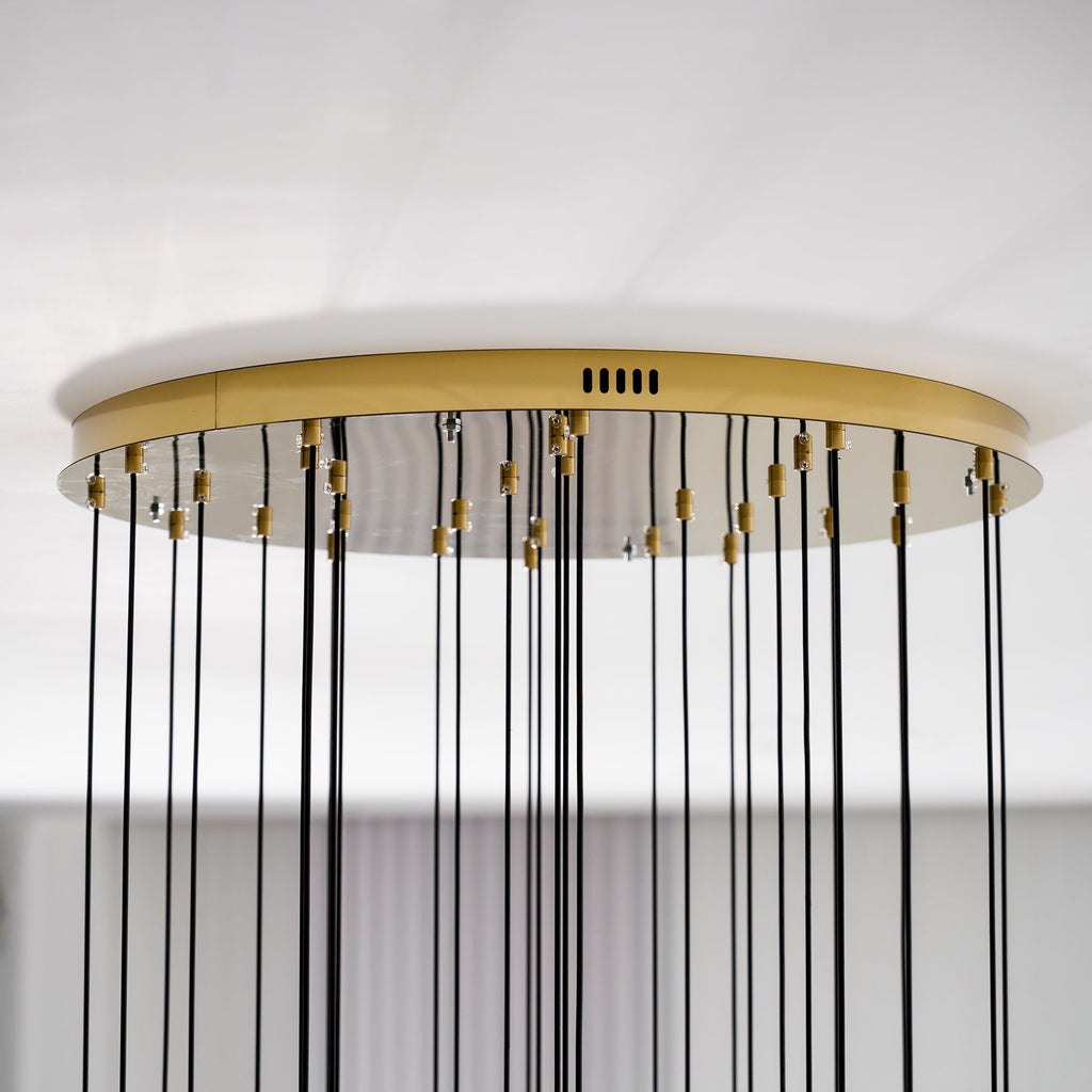 Side view of the Clérachic Cascading Globe Chandelier canopy, a slim polished gold disc holding every black flex against the ceiling.