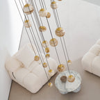 Unlit by day, the Clérachic Cascading Globe Chandelier spheres read warm off-white, banding shifting from one quarried stone to the next.
