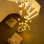 Night view from above of the Clérachic Cascading Globe Chandelier, warm pools of light falling across the floor and the seating below.