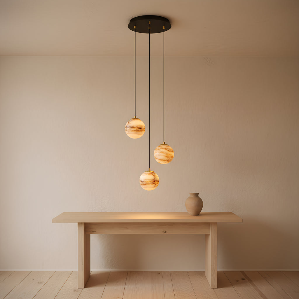 The three-head configuration above an oak console in an entrance hall, three lit alabaster spheres staggered beneath the matte black canopy