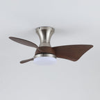 A Clérachic nickel ceiling fan with a cool white light on, showing its three dark walnut-grain blades against a pale grey ceiling.
