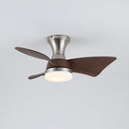 The Clérachic nickel fan with its light on a warm setting, three walnut-grain blades spread out against a pale grey ceiling.