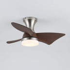 A Clérachic nickel ceiling fan from the side, with a warm glowing light and the blades swept around its slim trumpet-shaped canopy.