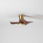 A side view of the Clérachic gold ceiling fan with an unlit white diffuser, blades slightly blurred against a grey-white ceiling.