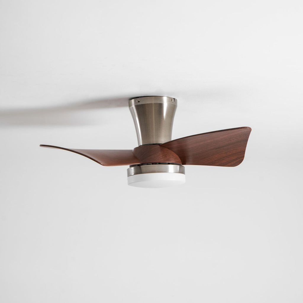A Clérachic nickel ceiling fan from the side with its light off, showing the blades slightly blurred as they turn.