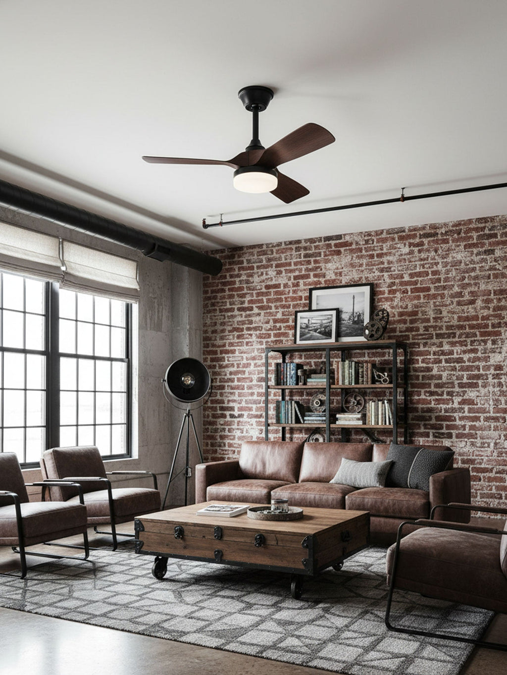 Seen from the side of a brick-walled loft, this Clérachic ceiling fan sits above a trunk-style coffee table and leather seating.