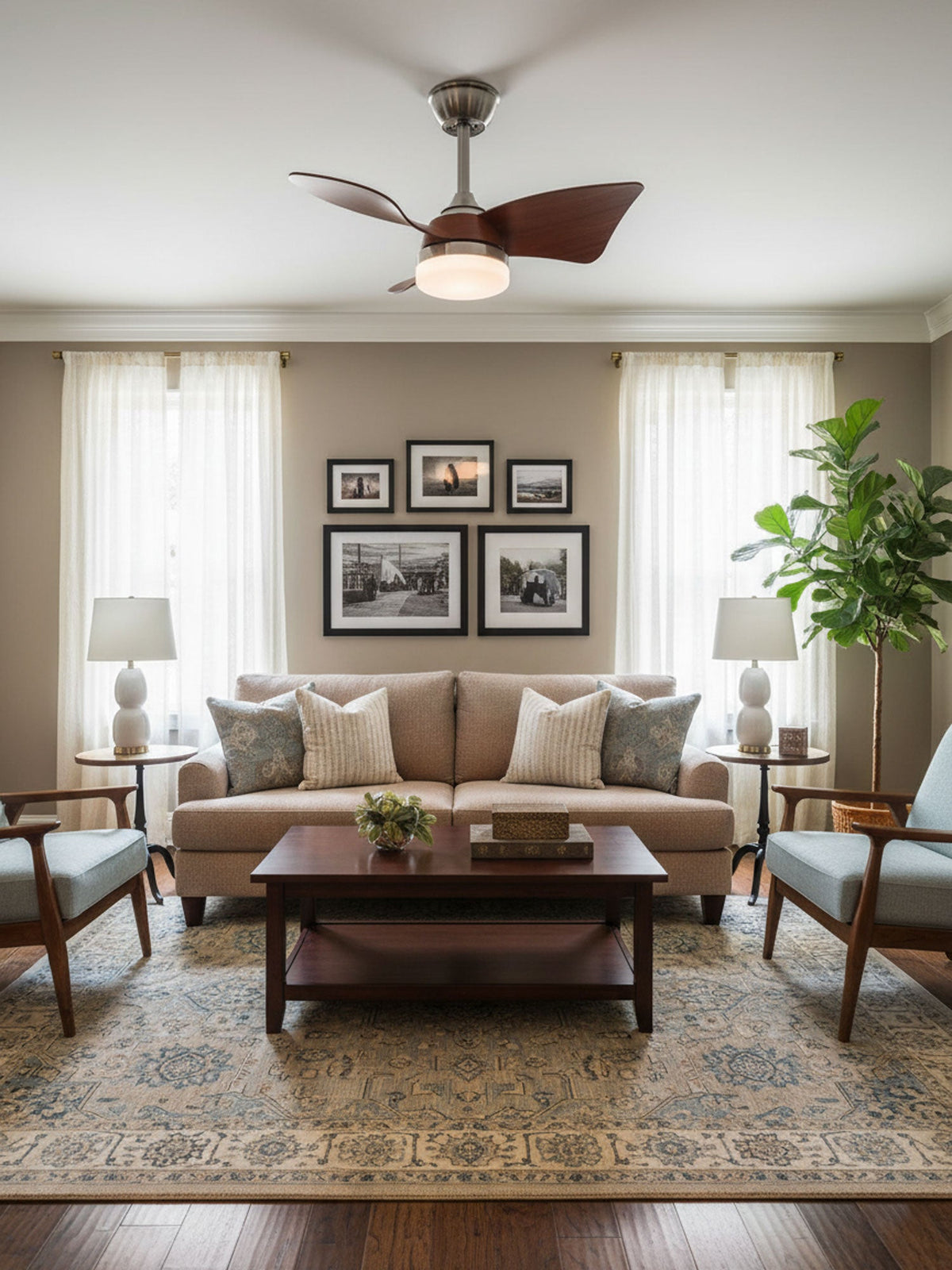 Walnut blades and a warm round light on this Clérachic fan, set above a traditional sitting room with a framed print wall.