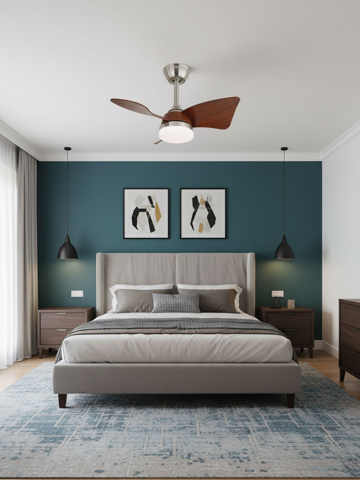 A small Clérachic fan with curved walnut blades hangs above a bed with a tall grey headboard and a teal accent wall.