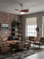 Looking up at this Clérachic fan from a brick-walled living room with black shelving, a tripod lamp and a leather sofa.
