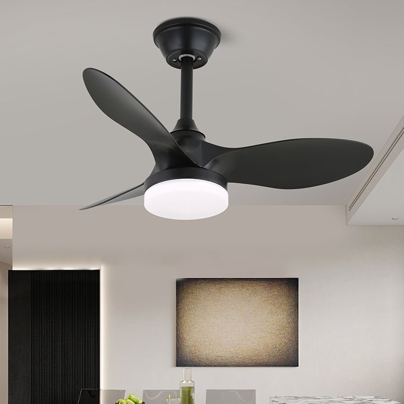 A black version of this Clérachic ceiling fan, with three matt black blades and a lit white light, in a bright modern room.