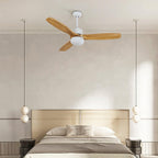 White-and-wood ceiling fan with light from Clérachic turning above a bed with a rattan headboard and two globe pendant lights.