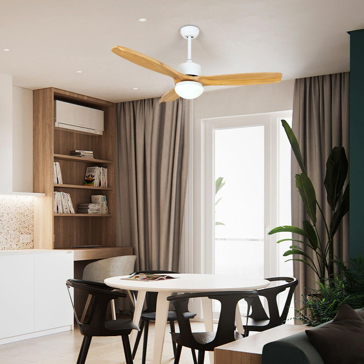 Clérachic ceiling fan with pale wooden blades and a round light, above a dining area with a white table, black chairs and tall shelves.