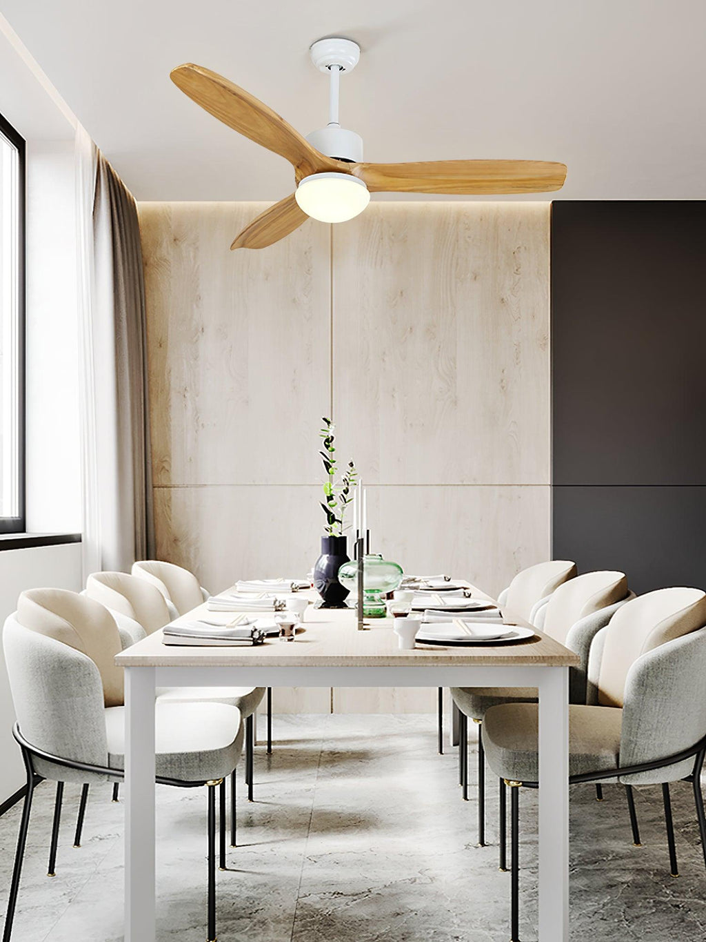 Light wooden-bladed ceiling fan from Clérachic above a dining table with cream chairs, in a room with a pale panelled wall.