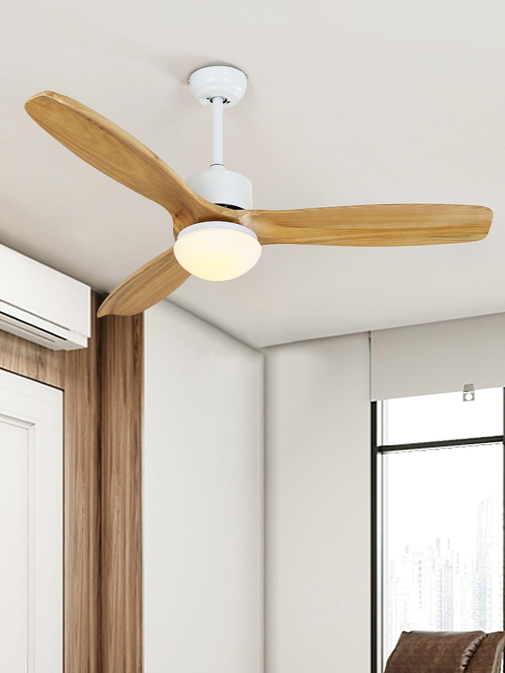 Ceiling fan from Clérachic with a white downrod and warm-lit shade, angled above a corner with a window and a wooden door frame.