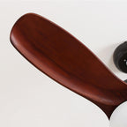 Close view of a dark red-brown wooden blade on this Clérachic ceiling fan, with the black motor housing at the edge.